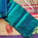 Completely plain tissue by cotton saree in blue and sea green two tone and red slub border. The pallu has sea green tassels. 
Does not come with a blouse. 