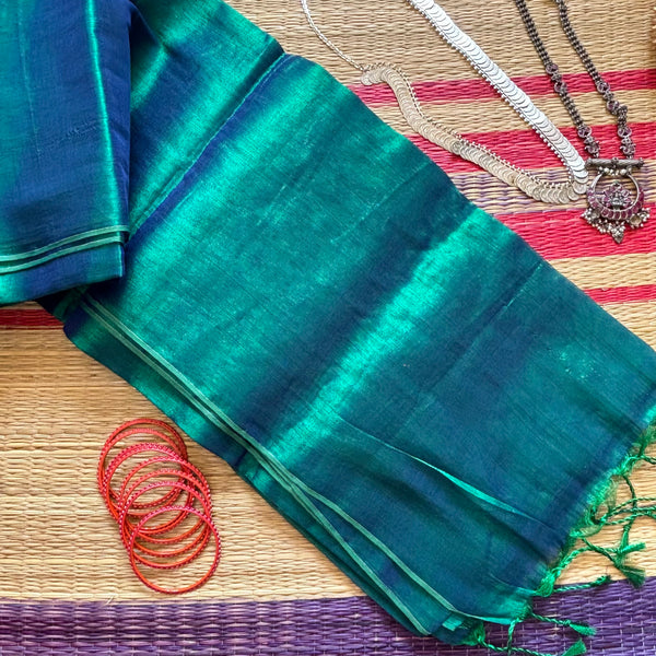 Completely plain tissue by cotton saree in blue and sea green two tone and red slub border. The pallu has sea green tassels. 
Does not come with a blouse. 
