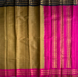 Madhumati is a traditional Gadwal cotton in hazelnut brown with pure silk Ganga-Jamuna borders in pink and black and pure silk palla in pink.